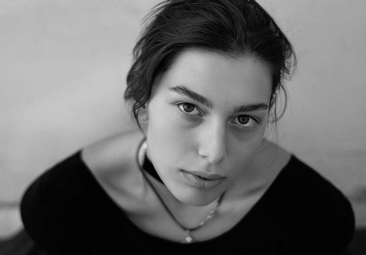 Black and white artistic portrait of a young woman with natural expression.